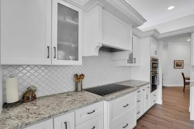 a kitchen with granite countertop white cabinets and a sink