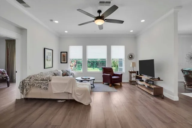 a living room with furniture floor to ceiling window and a flat screen tv