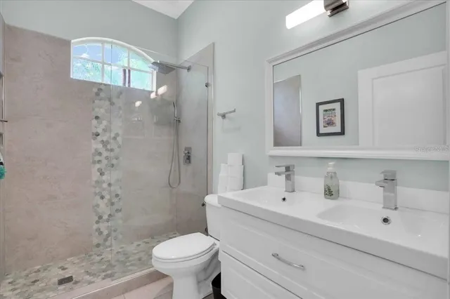 a bathroom with a sink a toilet and shower