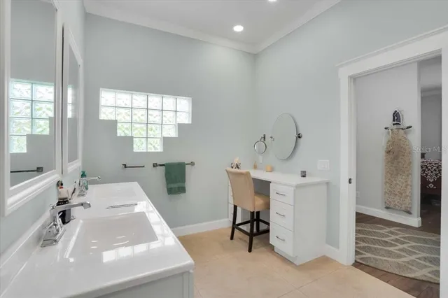 a en suite bathroom with a double vanity sink a mirror and a bathtub