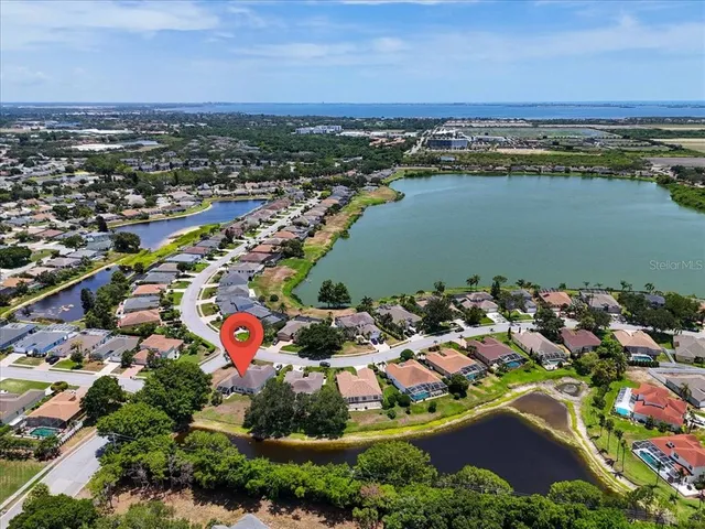 an aerial view of a city with lots of residential buildings ocean and mountain view in back