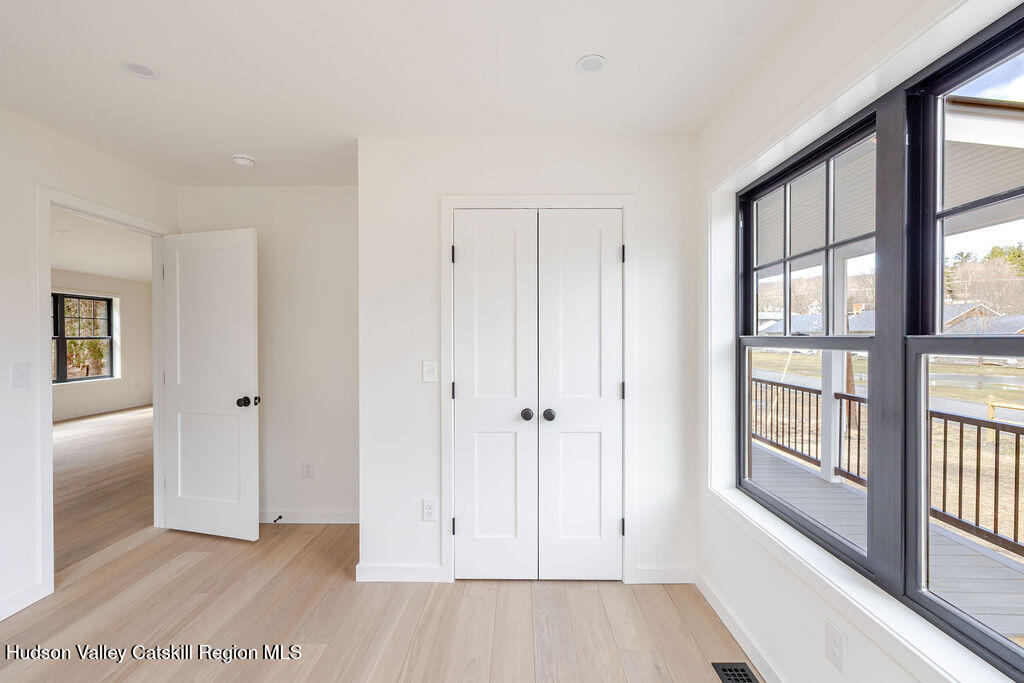 217 Anthony Street Copake, NY 12529 - Photo 20 of 23 a view of an empty room with a window and wooden floor