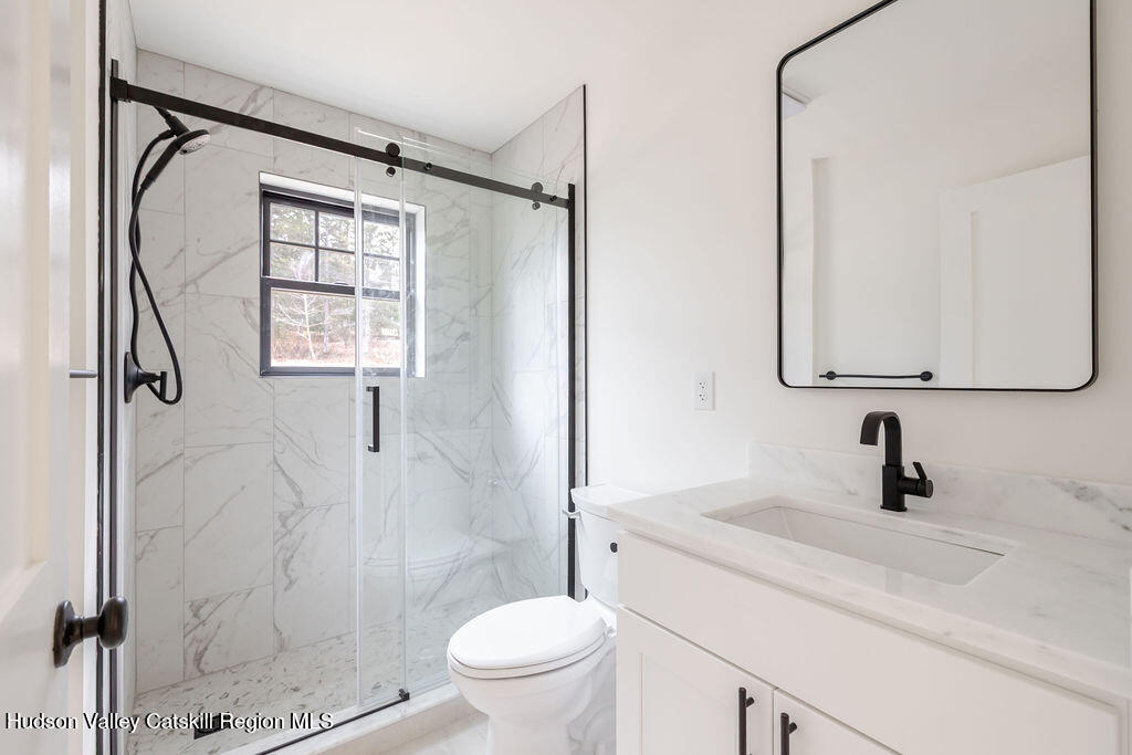 217 Anthony Street Copake, NY 12529 - Photo 21 of 23 a bathroom with a granite countertop sink a toilet and shower