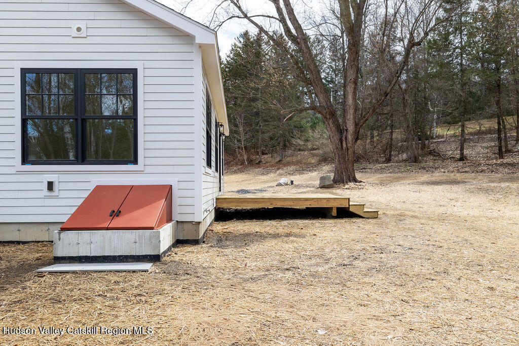 217 Anthony Street Copake, NY 12529 - Photo 4 of 23 a backyard of a house with wooden fence and large trees