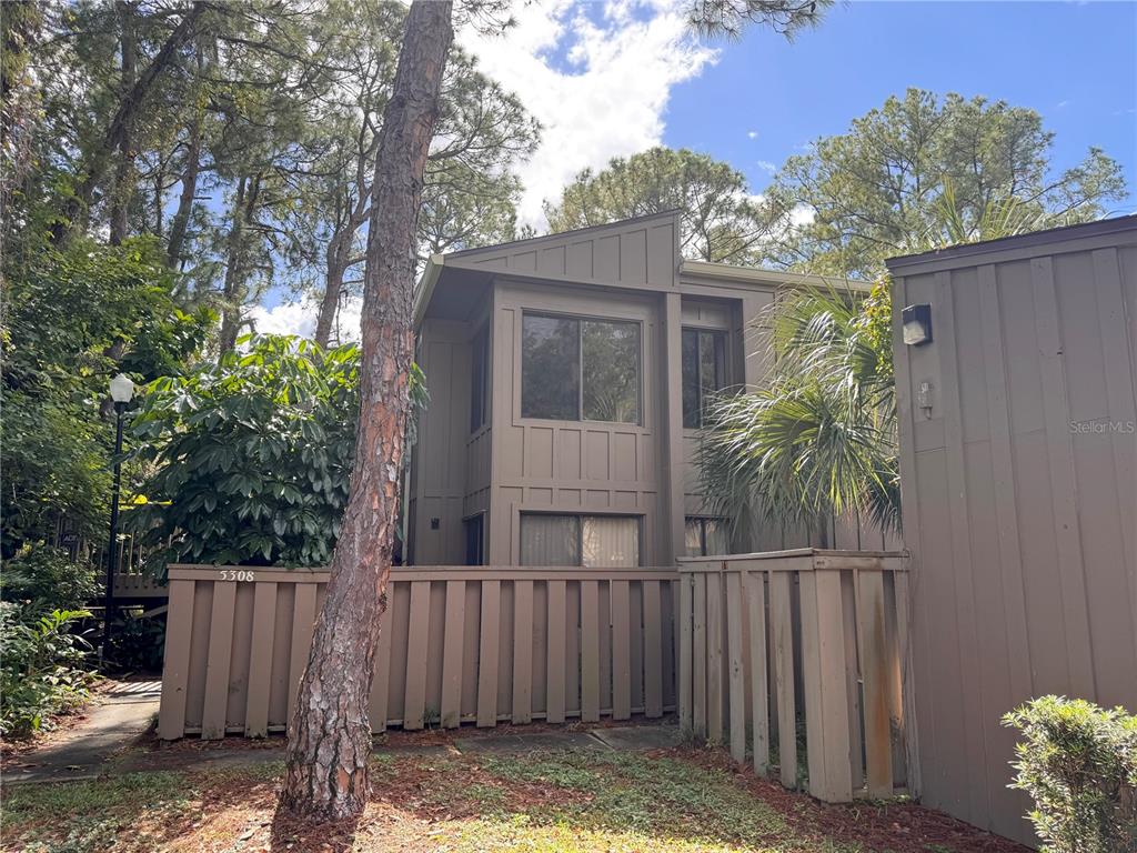 5310 Pebble Beach Drive, Unit F022 Orlando, FL 32811 - Photo 1 of 22 a view of a house with a small yard and wooden fence