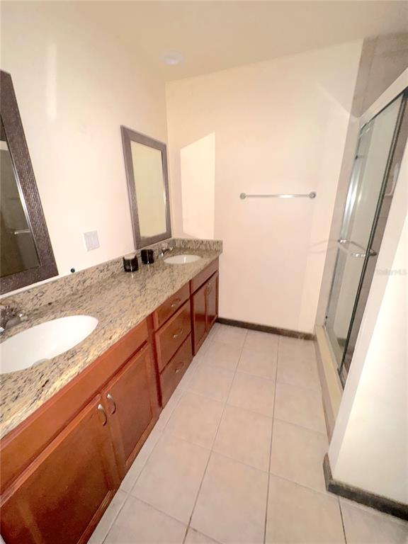 5310 Pebble Beach Drive, Unit F022 Orlando, FL 32811 - Photo 11 of 22 a bathroom with a granite countertop sink and a mirror