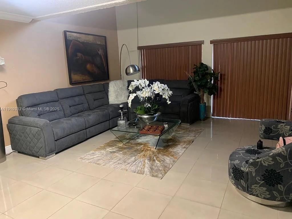 18051 Northwest 68th Avenue, Unit L104 Hialeah, FL 33015 - Photo 2 of 9 a living room with furniture flowerpot and a potted plant