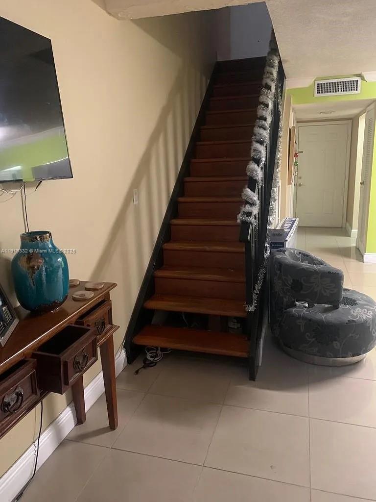 18051 Northwest 68th Avenue, Unit L104 Hialeah, FL 33015 - Photo 3 of 9 a living room with furniture and a flat screen tv