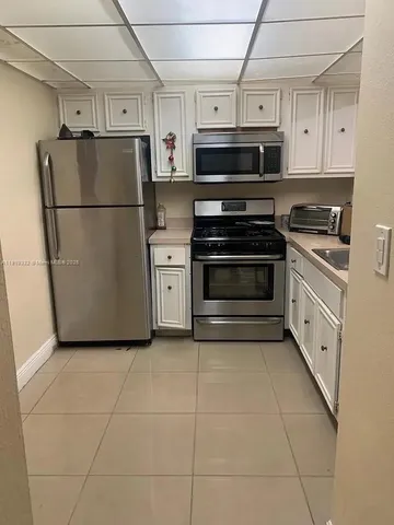 a kitchen with stainless steel appliances a refrigerator sink and cabinets