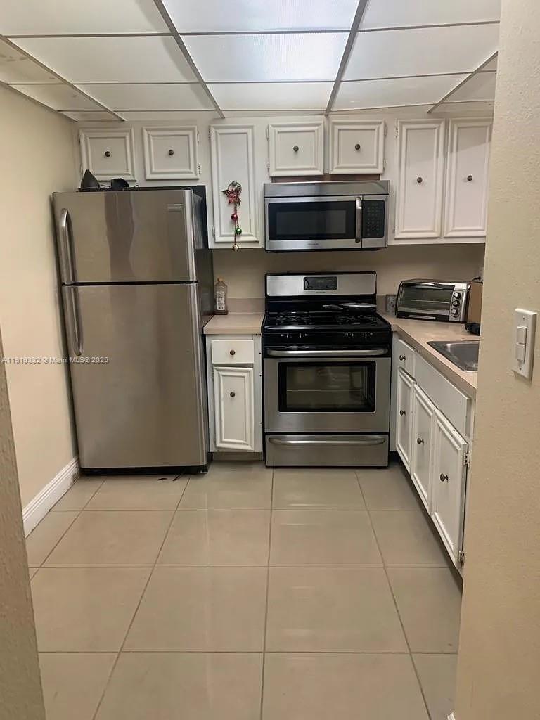 18051 Northwest 68th Avenue, Unit L104 Hialeah, FL 33015 - Photo 6 of 9 a kitchen with stainless steel appliances a refrigerator sink and cabinets