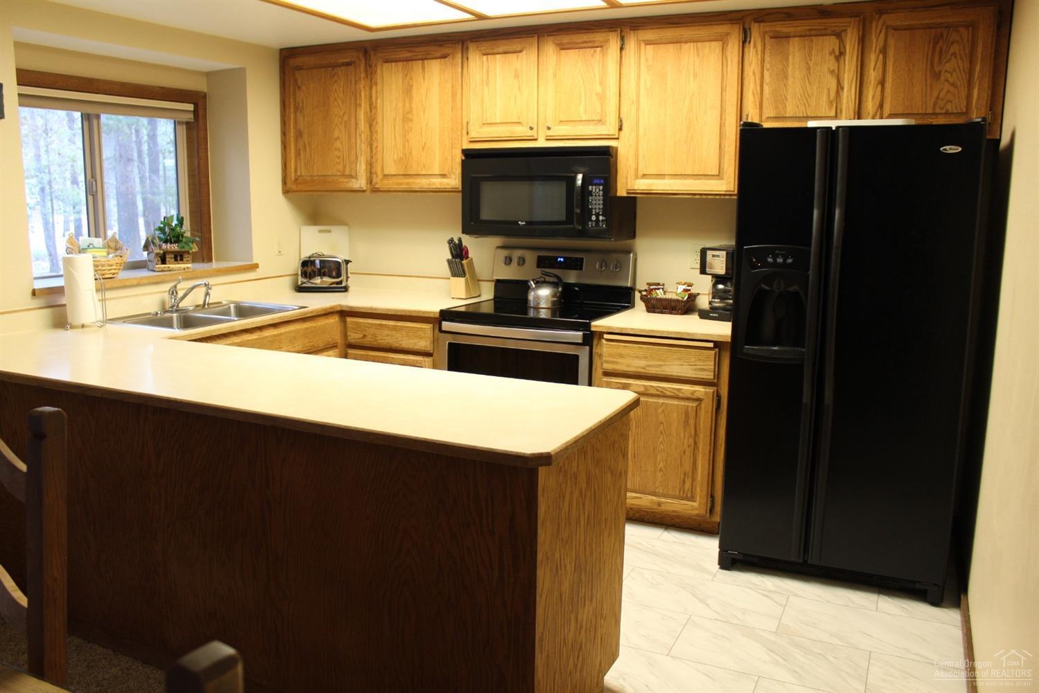 57328 Beaver Ridge Loop Sunriver, OR 97707 - Photo 8 of 22 a kitchen with a sink a stove and a refrigerator