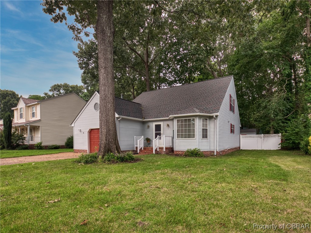 View of front of home with a garage and a front lawn