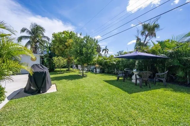 a view of a backyard with table and chairs under an umbrella