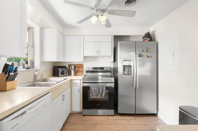a kitchen with a refrigerator sink and cabinets