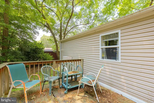 a balcony with wooden floor and yard in the back
