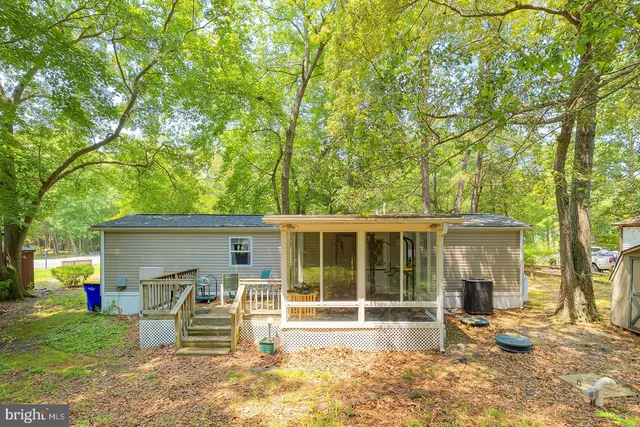 a view of a house with a yard and large tree