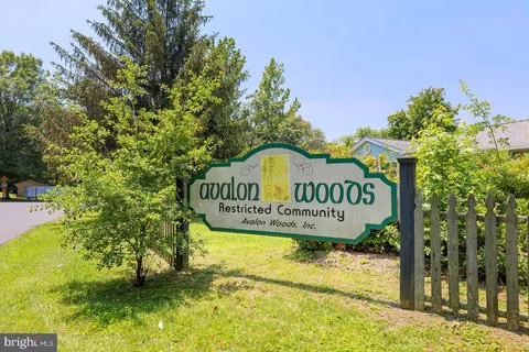a view of a sign board with large tree