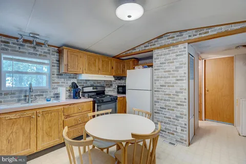 a kitchen with stainless steel appliances granite countertop a sink and a refrigerator