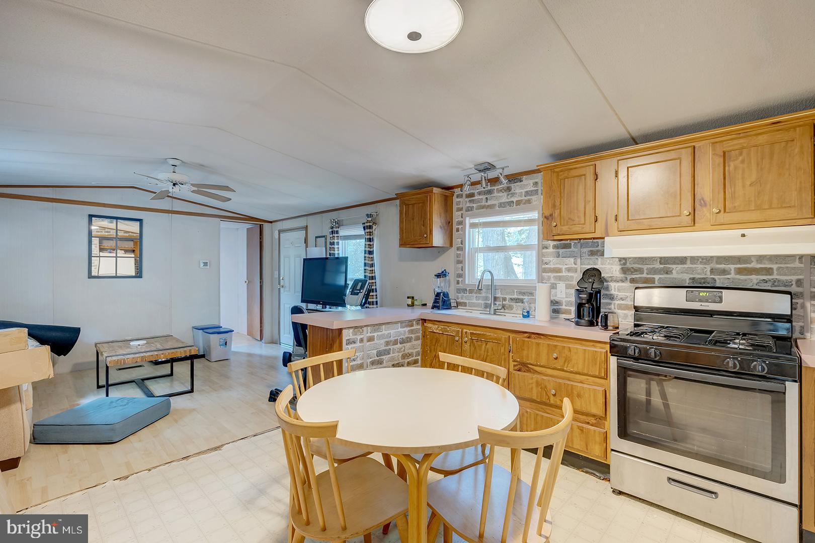 24119 Celtic Street Georgetown, DE 19947 - Photo 10 of 45 a kitchen with stainless steel appliances granite countertop a stove a sink dishwasher and cabinets with wooden floor