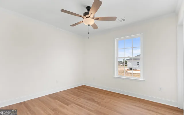an empty room with a window and a ceiling fan