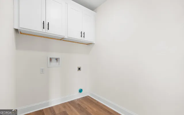 a view of a kitchen with white cabinets and wooden floor