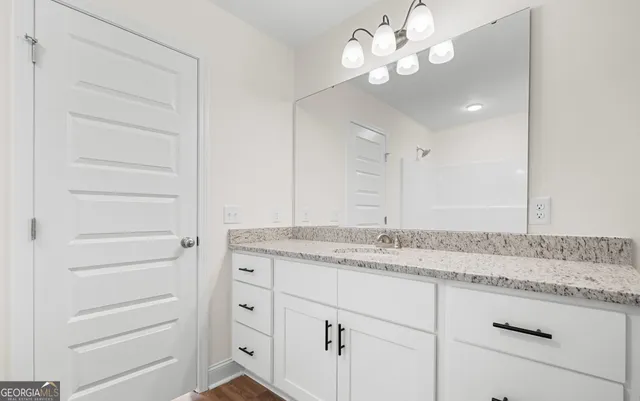a bathroom with a granite countertop sink and a mirror