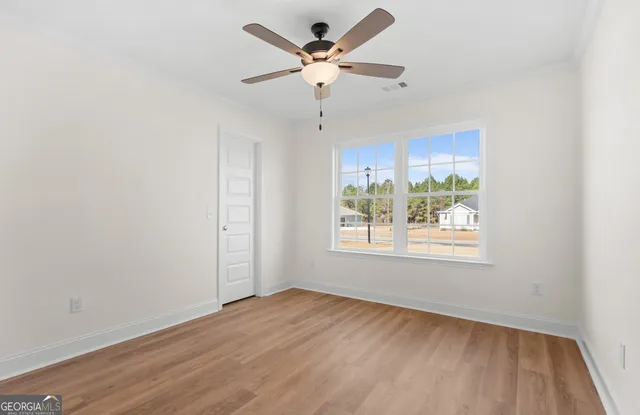 an empty room with fan and windows