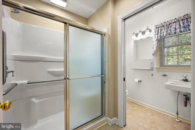 a bathroom with a toilet a sink and shower
