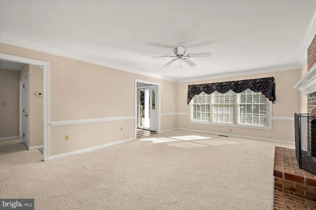 an empty room with windows and fireplace