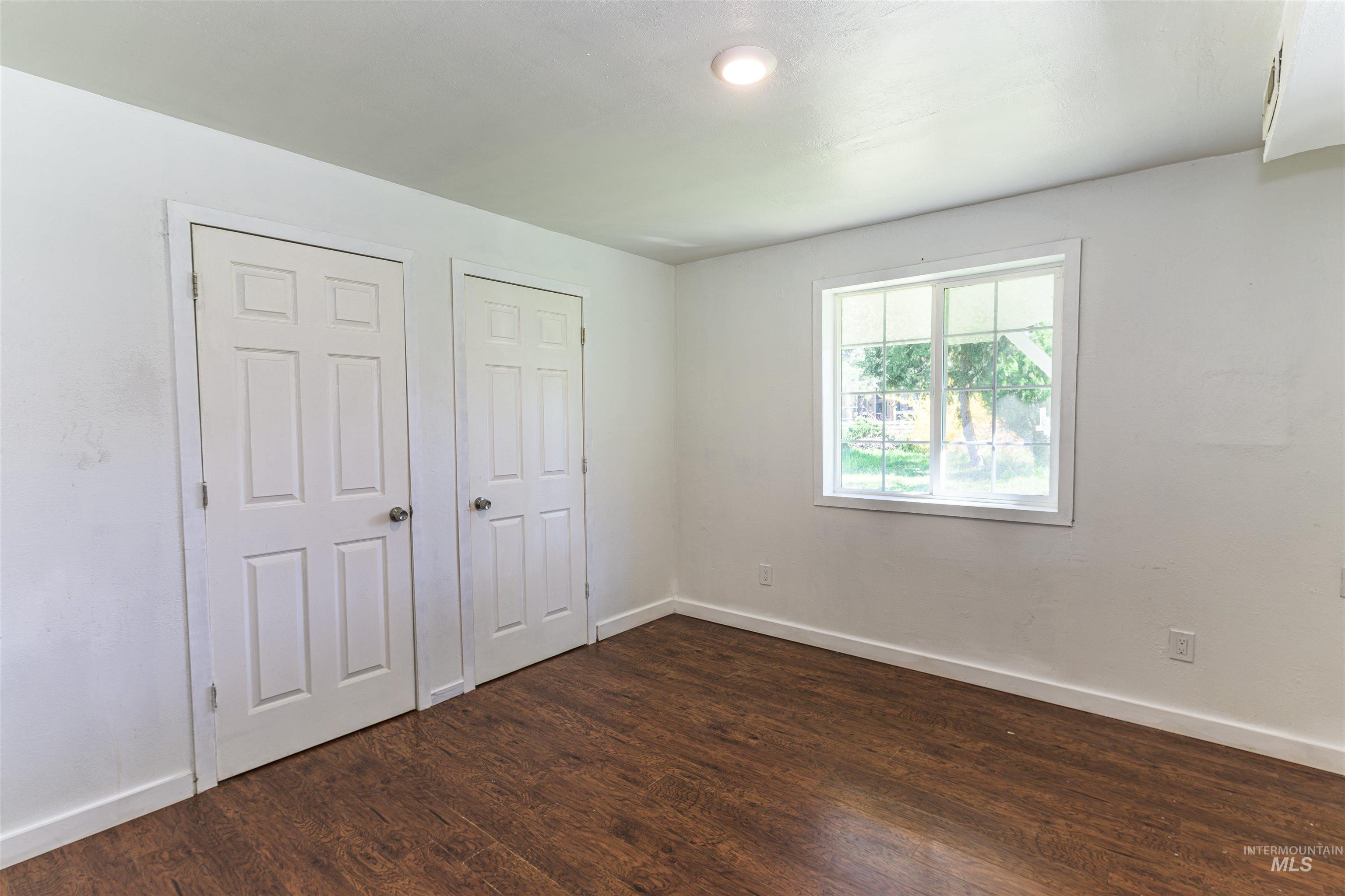 2003 North Cole Road Boise, ID 83704 - Photo 16 of 40 Unfurnished bedroom with dark wood-style floors and a closet