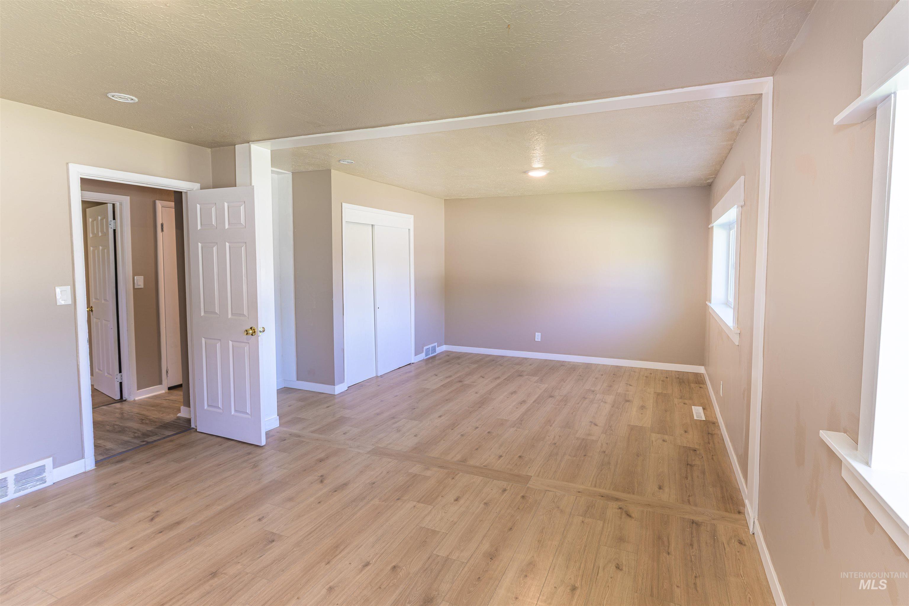 2003 North Cole Road Boise, ID 83704 - Photo 23 of 40 Empty room with light wood-type flooring and a textured ceiling