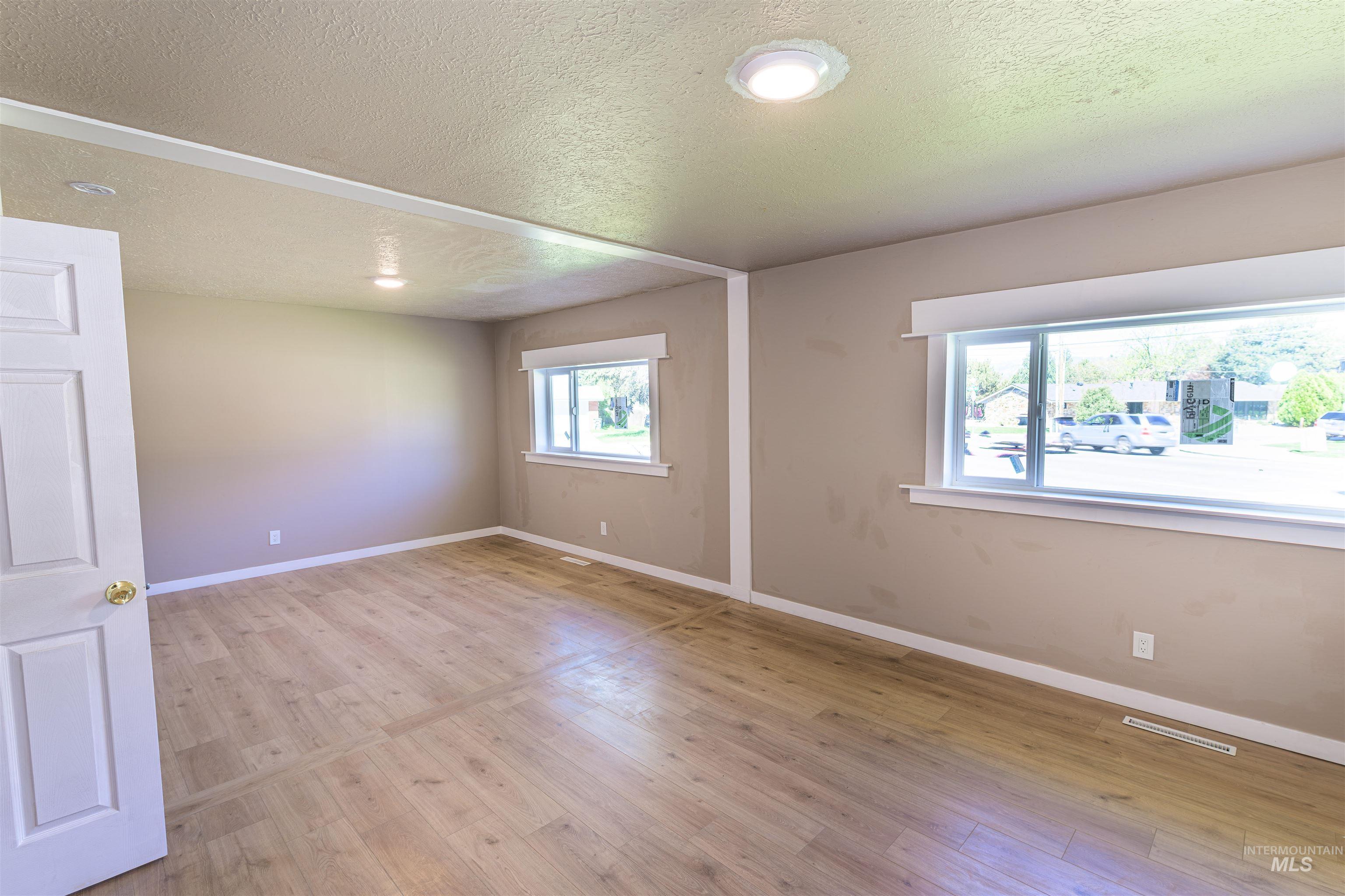 2003 North Cole Road Boise, ID 83704 - Photo 24 of 40 Spare room with light wood finished floors and a textured ceiling