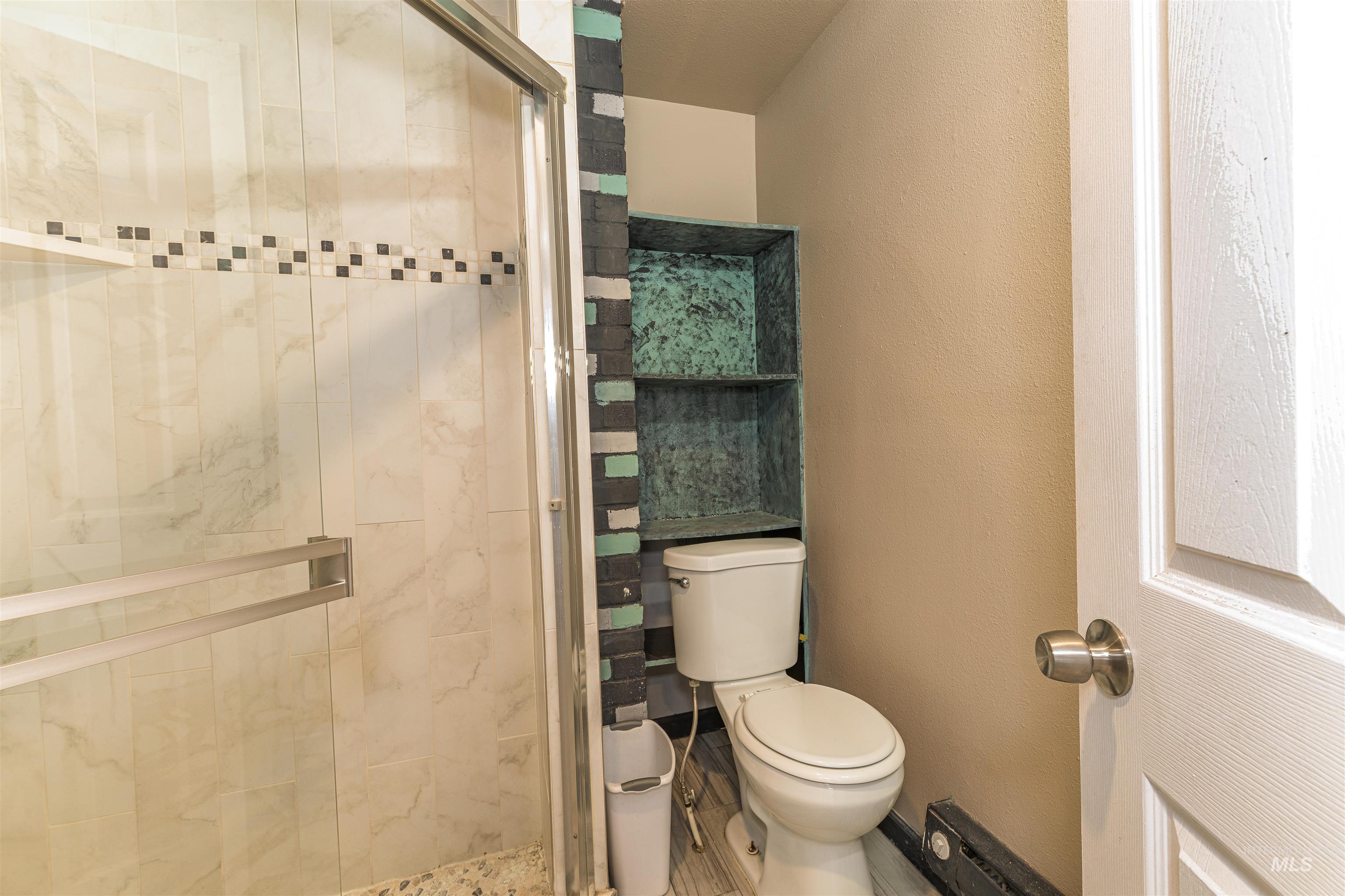 2003 North Cole Road Boise, ID 83704 - Photo 27 of 40 Bathroom featuring a shower stall and a textured wall