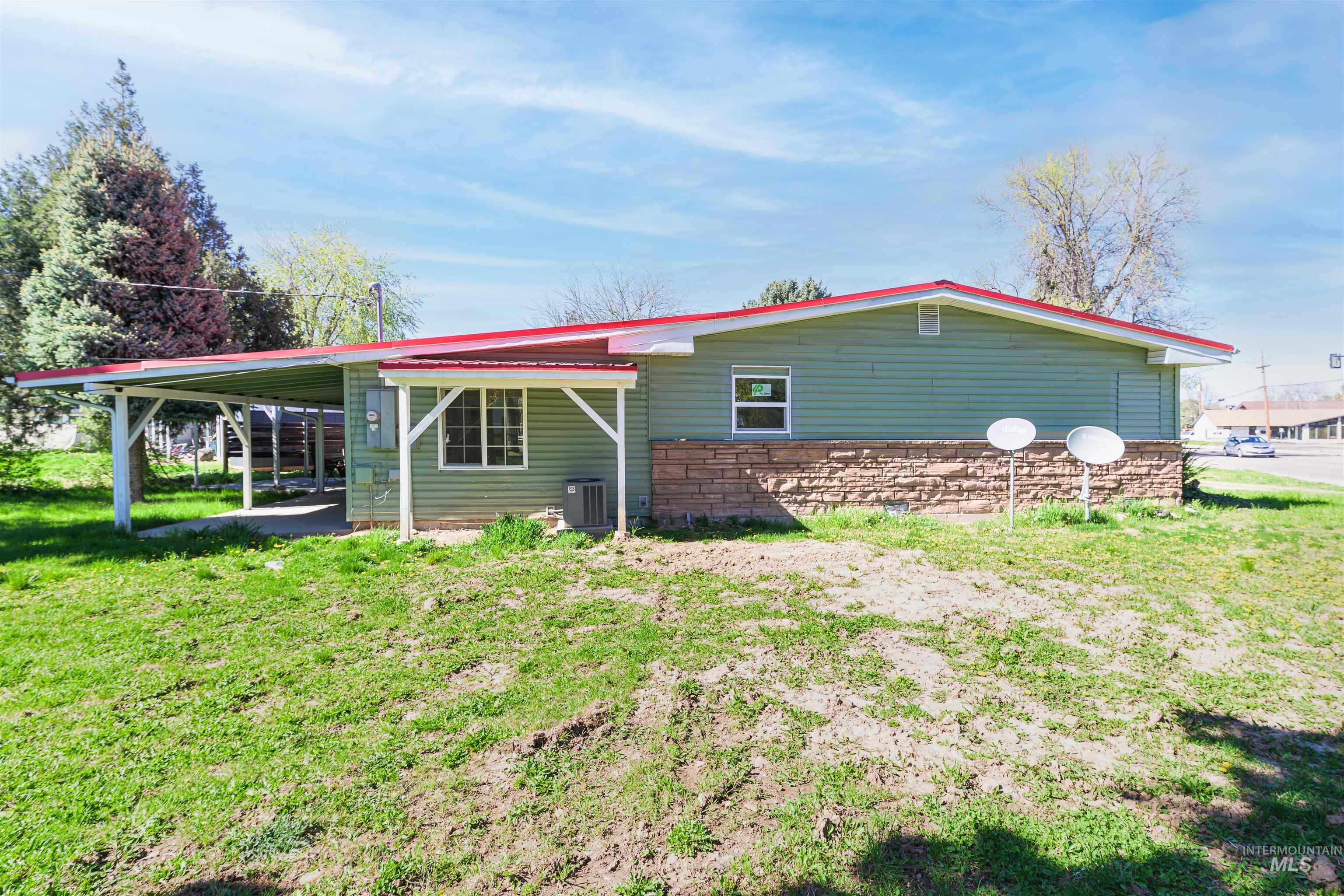 2003 North Cole Road Boise, ID 83704 - Photo 38 of 40 View of property exterior with an attached carport, a lawn, stone siding, and a patio