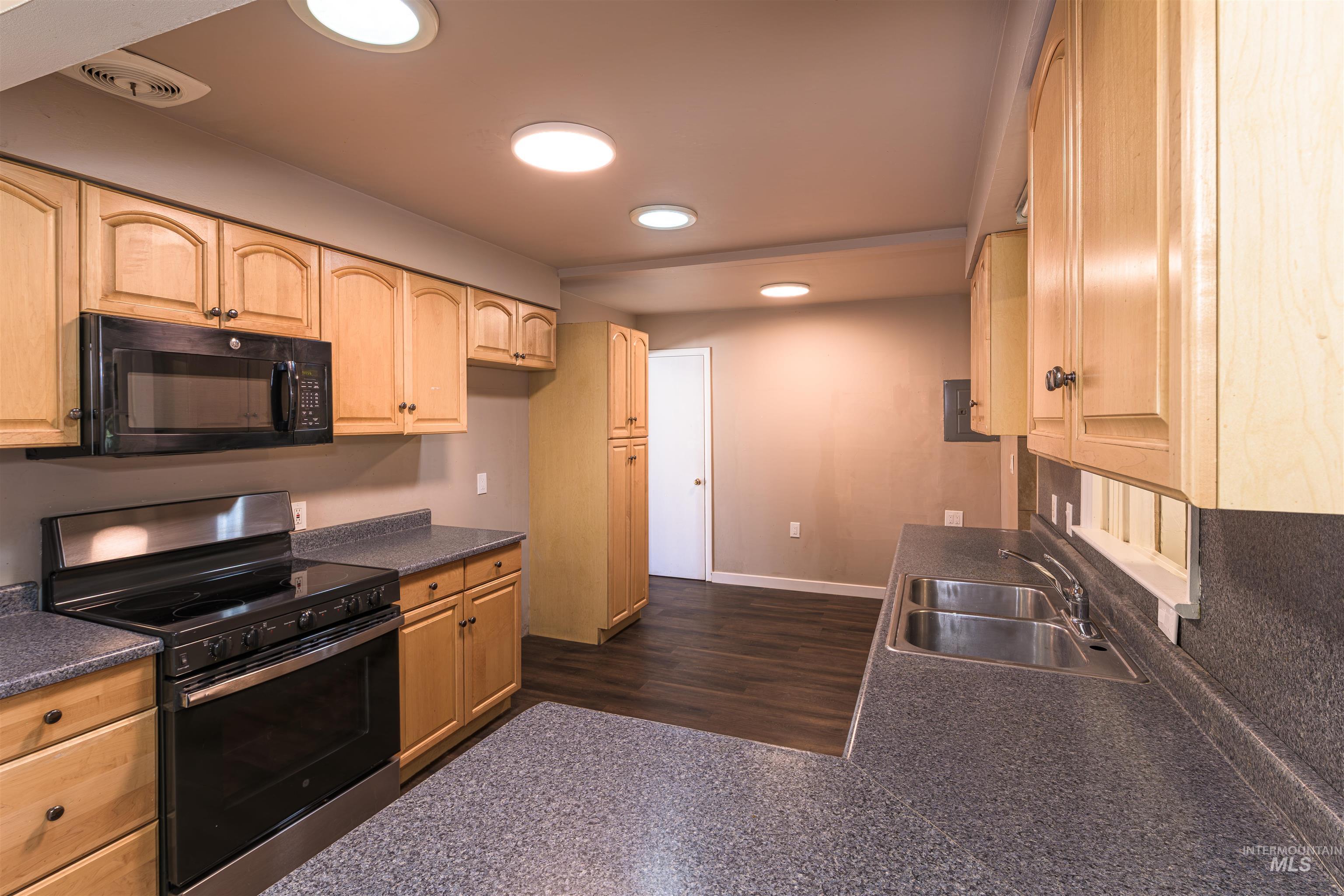 2003 North Cole Road Boise, ID 83704 - Photo 7 of 40 Kitchen featuring stainless steel range with electric stovetop, dark countertops, light wood finish cabinets, and black microwave