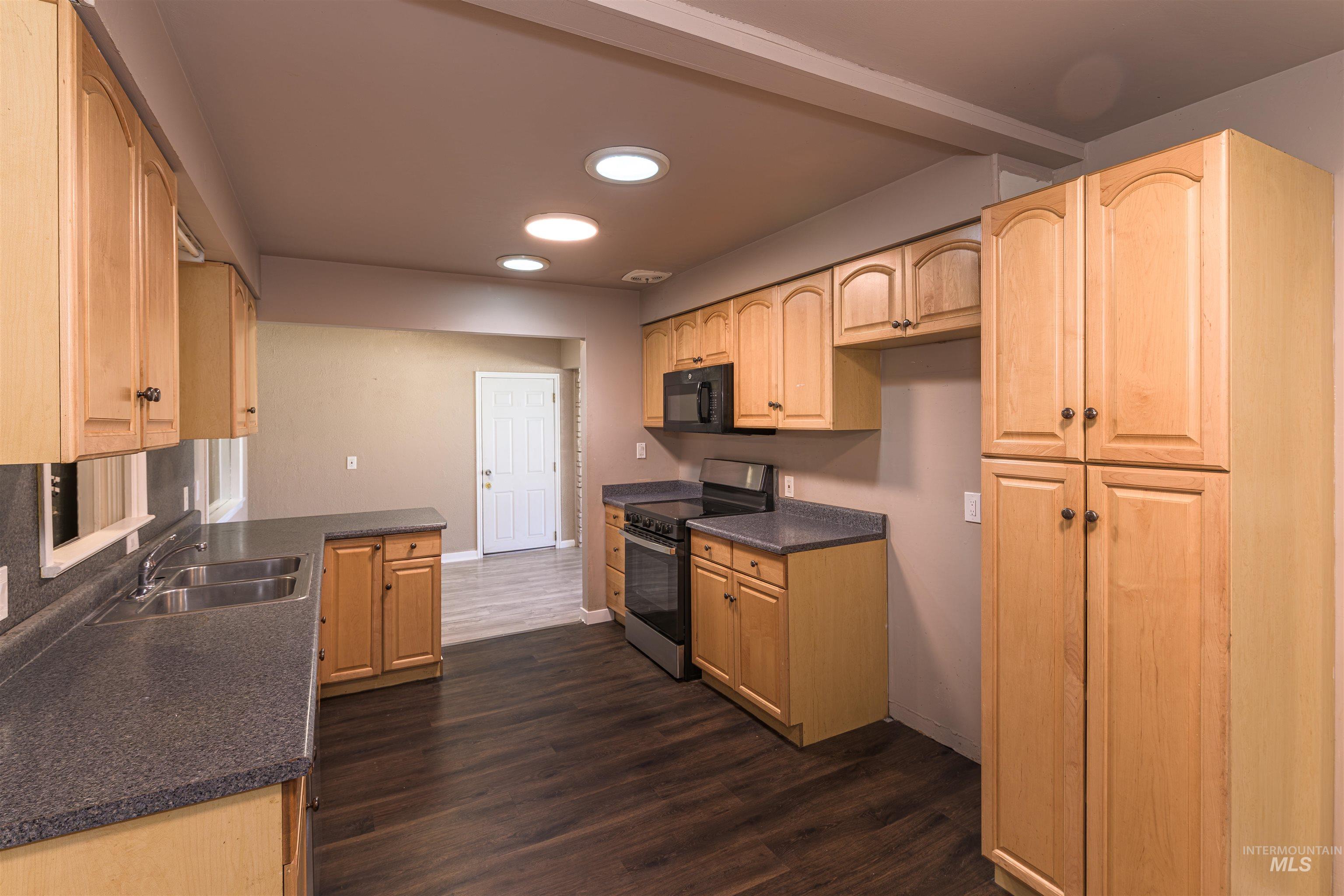 2003 North Cole Road Boise, ID 83704 - Photo 8 of 40 Kitchen featuring dark countertops, light wood finish cabinets, electric range, recessed lighting, and dark wood finished floors