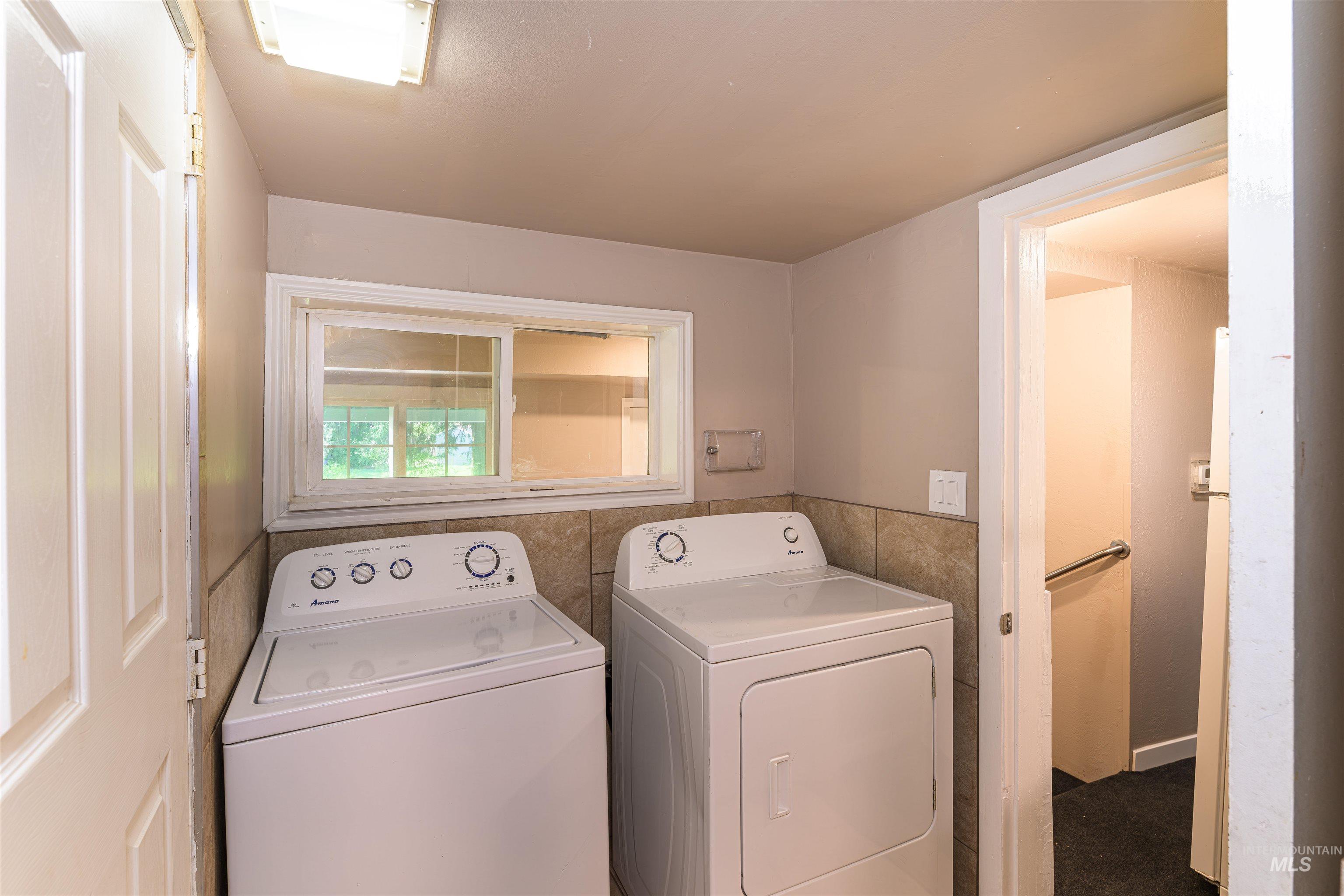 2003 North Cole Road Boise, ID 83704 - Photo 10 of 40 Laundry area featuring washing machine and clothes dryer and tile walls