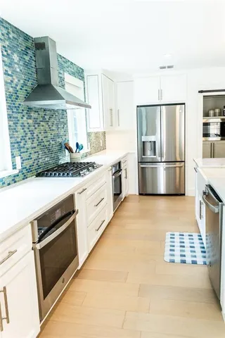 a kitchen with stainless steel appliances a stove a refrigerator and a sink