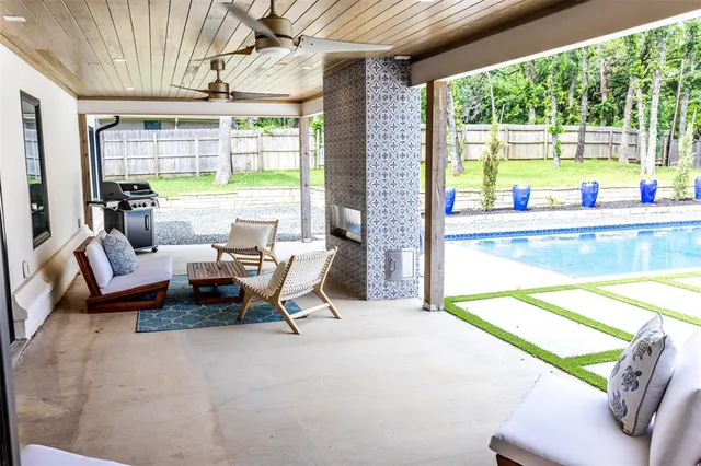 a living room with patio furniture and a floor to ceiling window