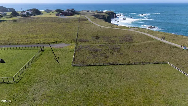 an aerial view of ocean with residential houses with outdoor space