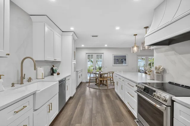 a kitchen with white cabinets and sink