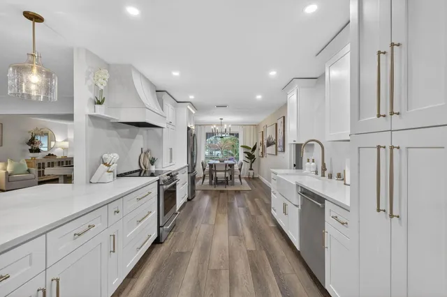 a kitchen with stainless steel appliances kitchen island hardwood floor sink and stove