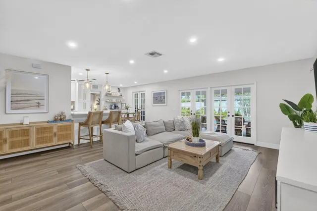 a living room with furniture a flat screen tv and a floor to ceiling window