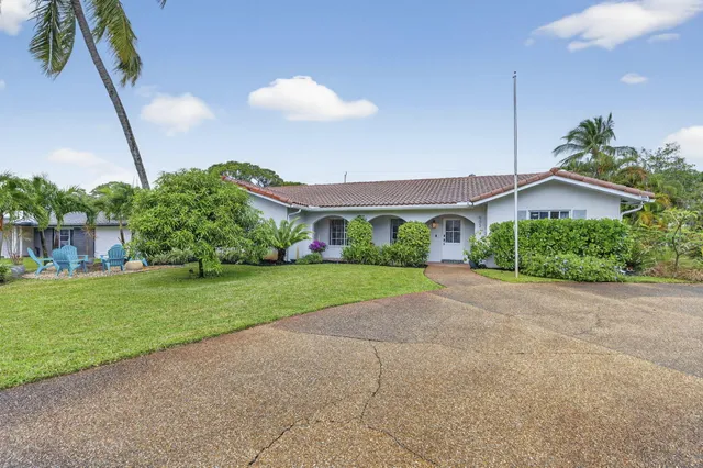 a view of a house with a yard and potted plants