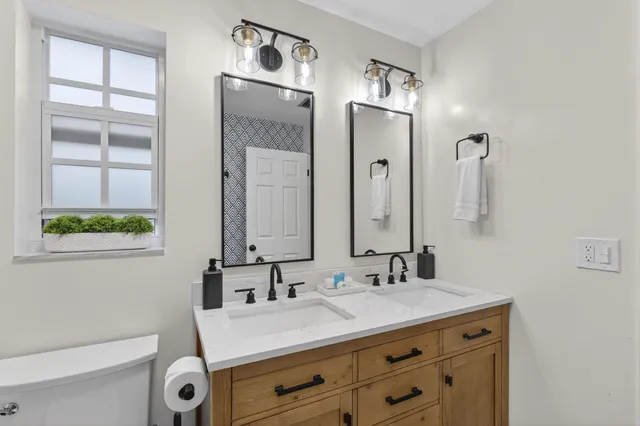 a bedroom with a bed a window and a chandelier