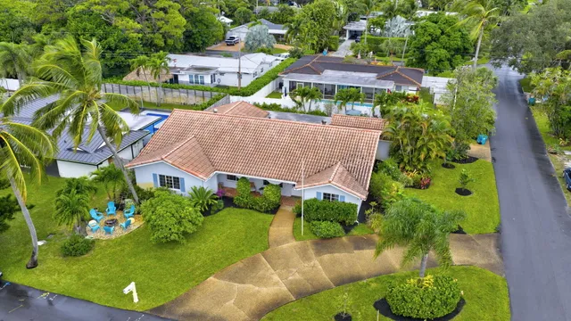 an aerial view of a house with a yard and lake view