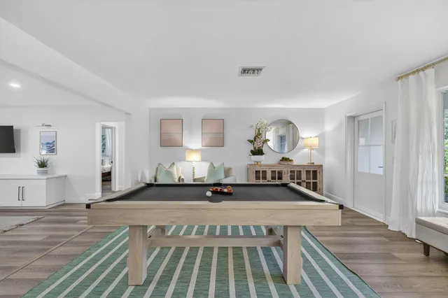 a spacious bedroom with a bed a mirror and a window