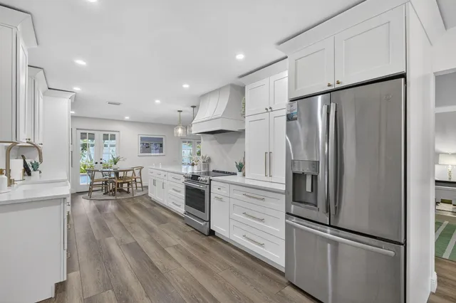 a large kitchen with stainless steel appliances lots of counter space and a sink
