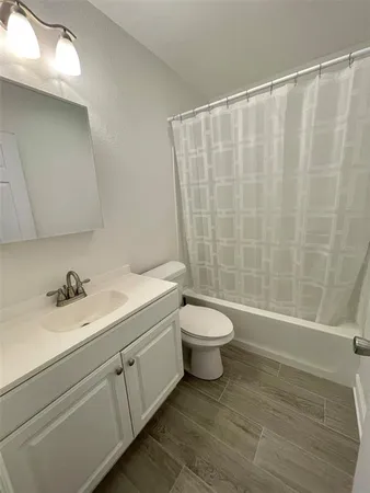 a bathroom with a sink a toilet and a shower