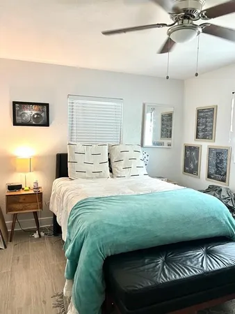 a bedroom with a bed mirror and a window